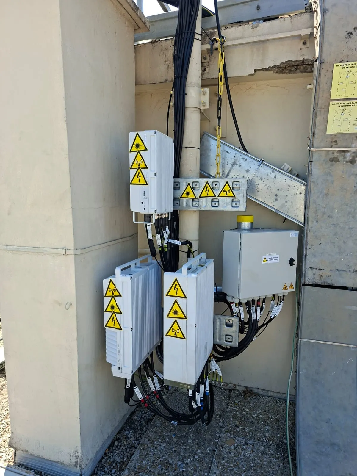 RRU et coffrets installés sur une toiture-terrasse avec chemins de câbles neufs, vue sur les collines de Nice