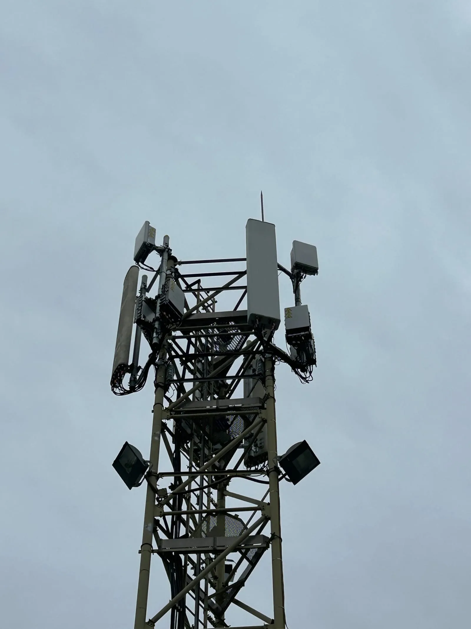 Tête de pylône équipée d'antennes et de RRU au coucher du soleil